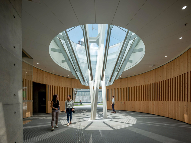 A central open inverted cone in the covered interior space that facilitates natural ventilation and lighting, creating comfortable indoor environment for the building users