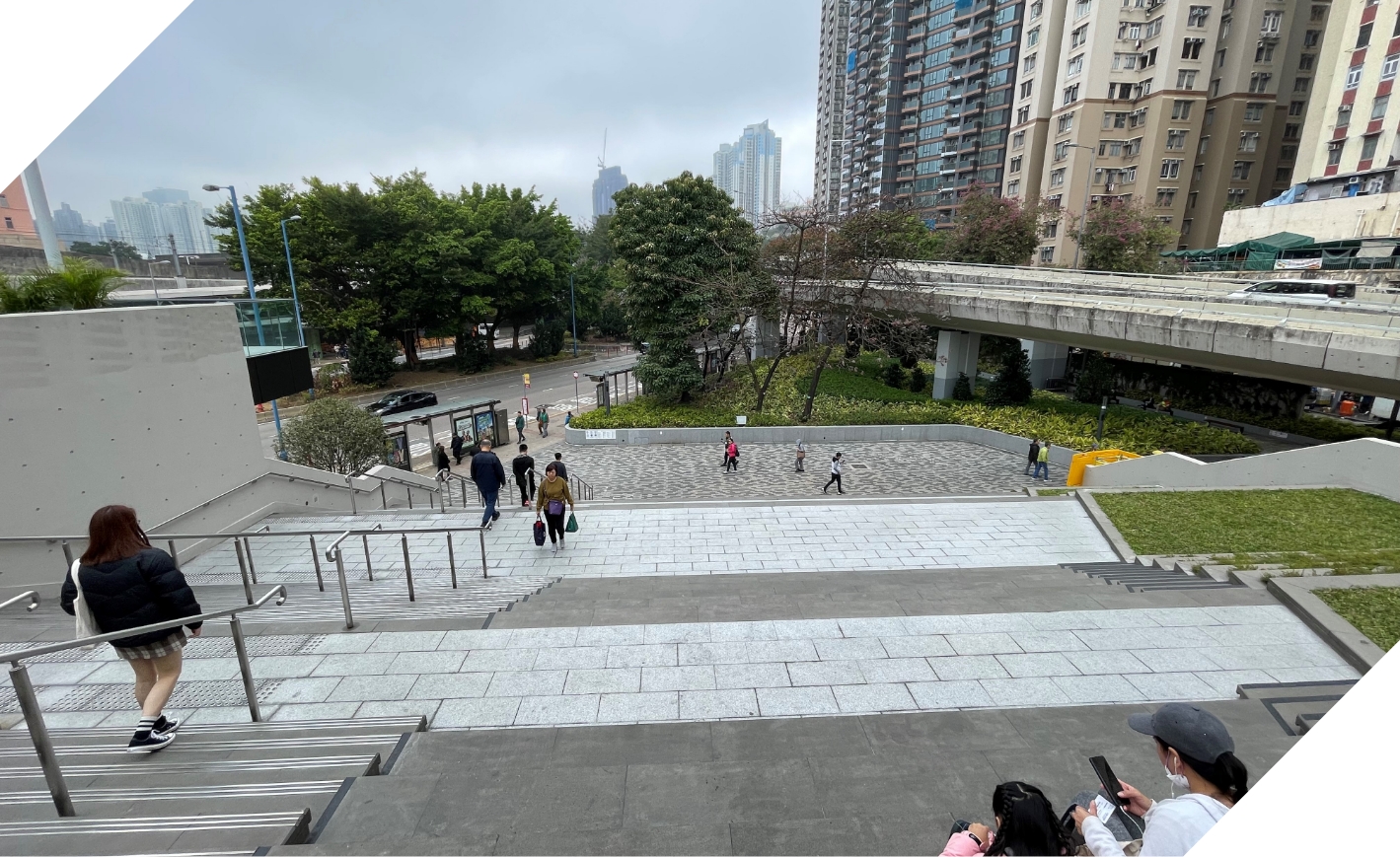 一樓平台經由天橋下的樓梯廣場與休憩花園，連接港鐵站與街道，讓使用者置身於翠綠樹梢中，享受舒適宜人的休憩時光。