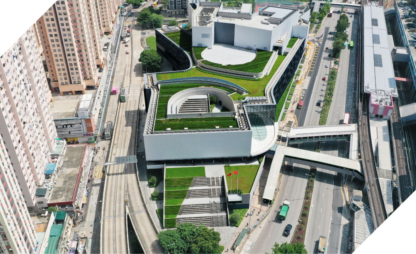 多層綠化空間由天台延伸至地面廣場，有助紓緩熱島效應，並營造親近自然的環境，為社區帶來舒緩視覺與多元活動的機會；入口廣場保留的樹木不僅遮蔭，更延續社區的集體回憶。