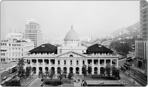 空曠的金鐘天空映襯下的立法會大樓，右邊是舊中國銀行大廈