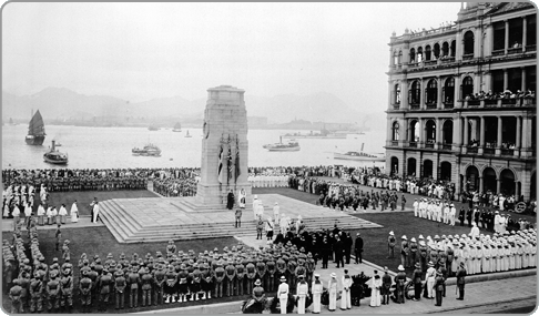 二十世紀五十年代填海工程前，在海旁聳立的和平紀念碑和舊香港會所大廈（右）
